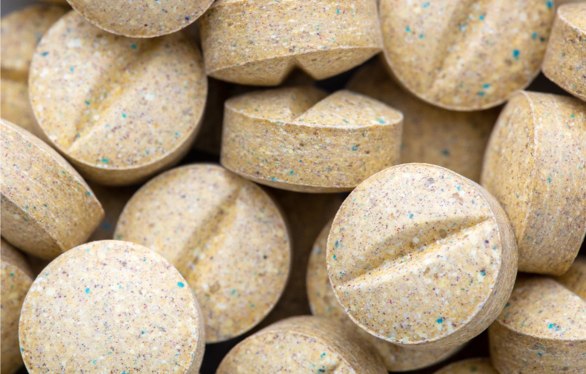 Zbliżenie na żółto-brązowe tabletki bakteryjne do szamba ułatwiające oczyszczanie ścieków