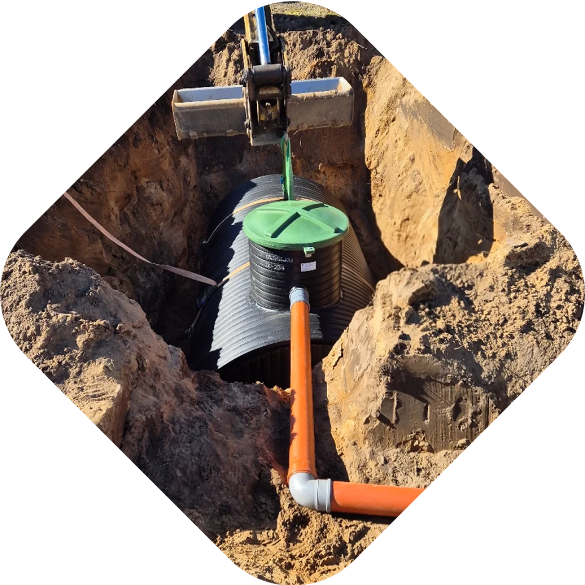 Montaż zbiornika na deszczówkę w wykopie z rurą odprowadzającą